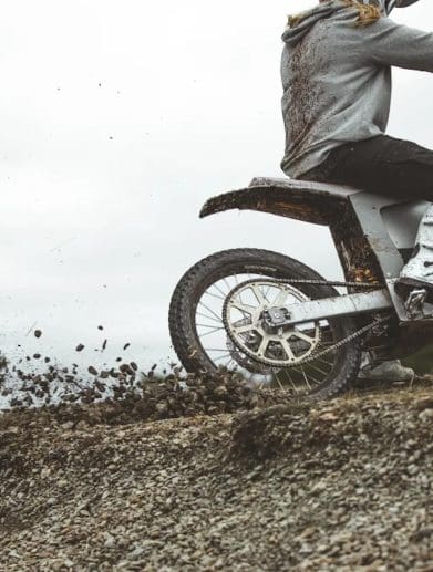 A motorcyclist riding an EV in the dirt.