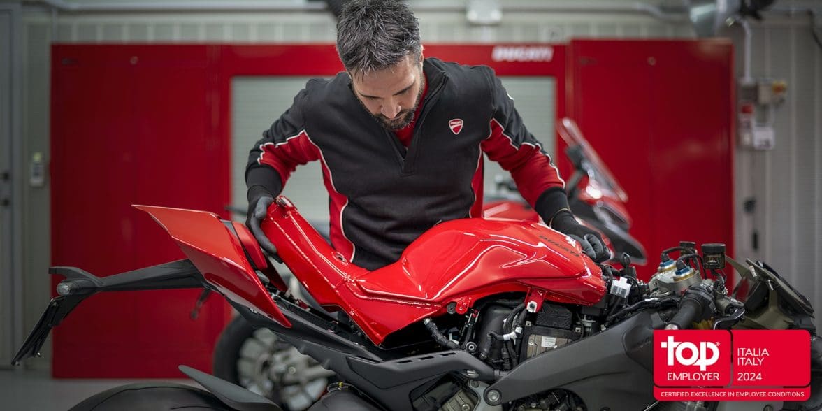 An employee looking at a motorcycle.