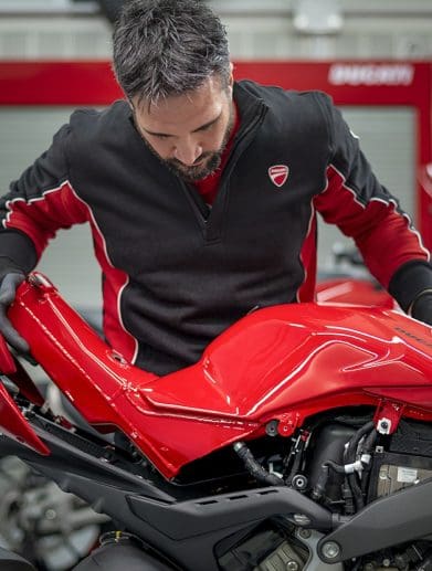 An employee looking at a motorcycle.