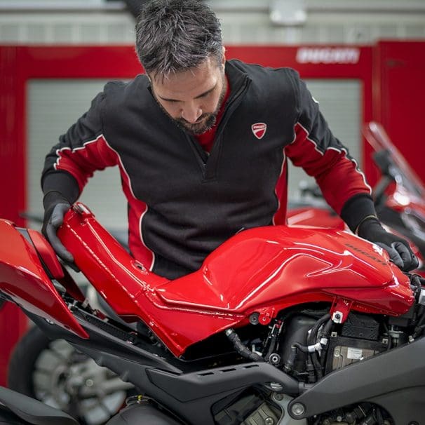 An employee looking at a motorcycle.