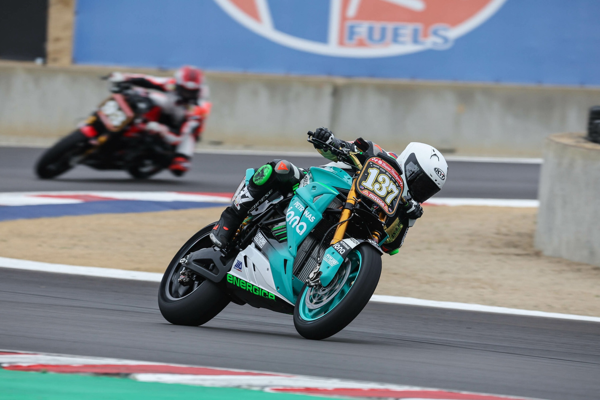 An electric superbike taking the lead on a race track.