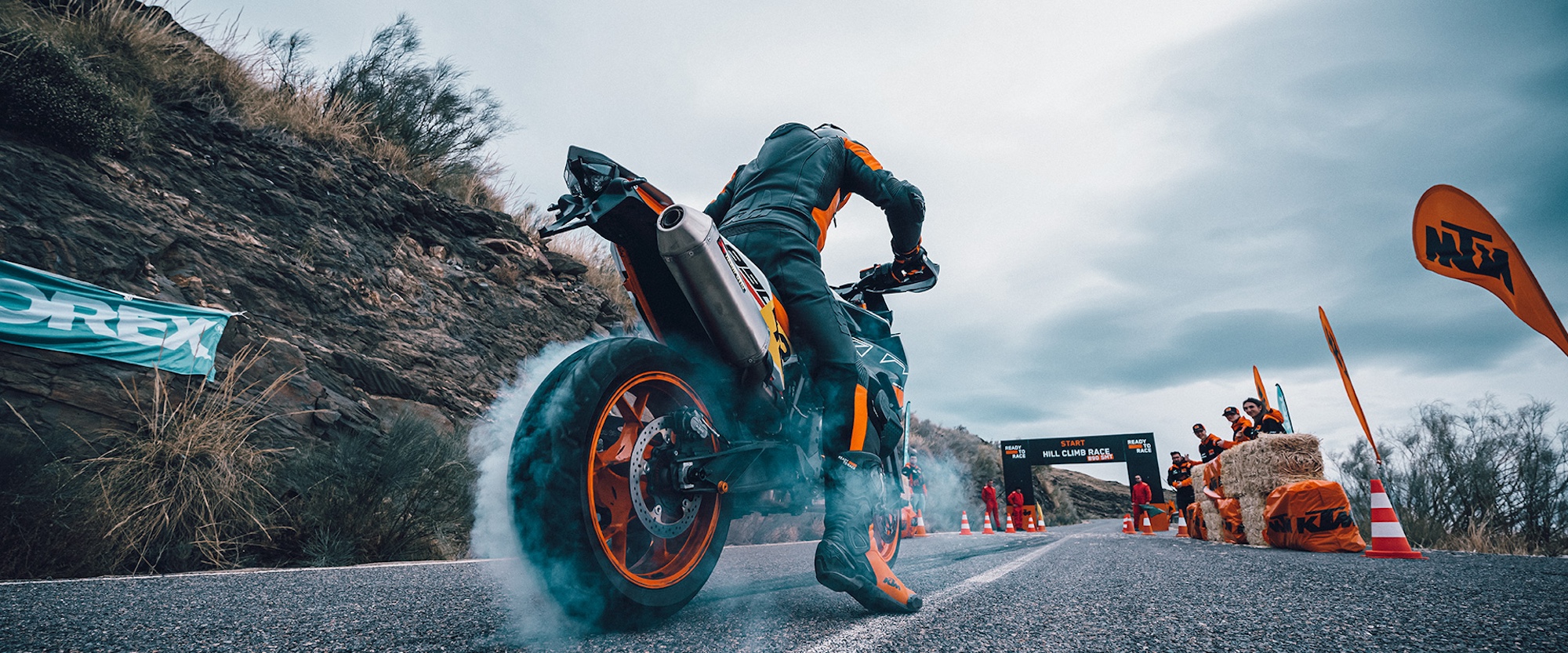 A motorcyclist pulling a burnout on a paved road.