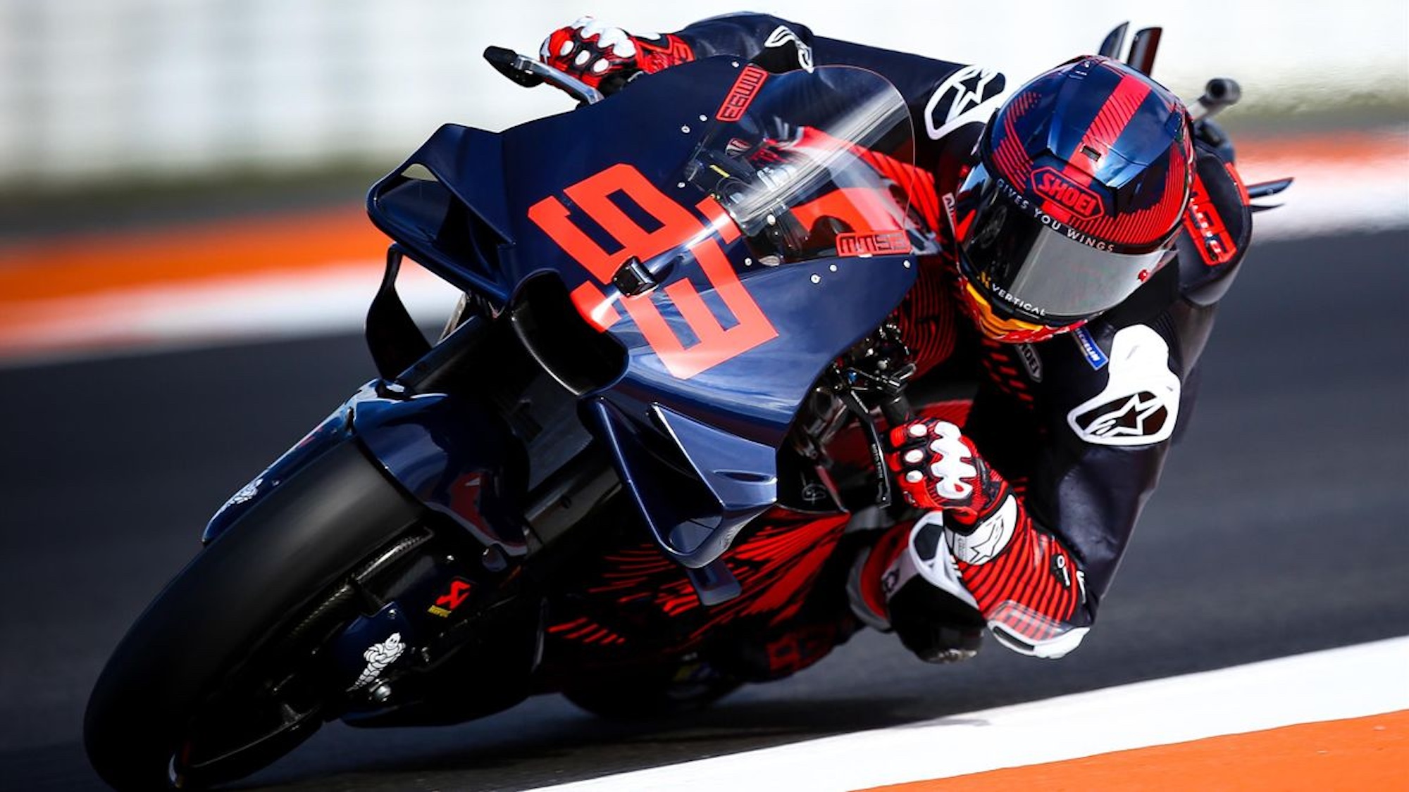 A front view of a MotoGP rider on a race track.