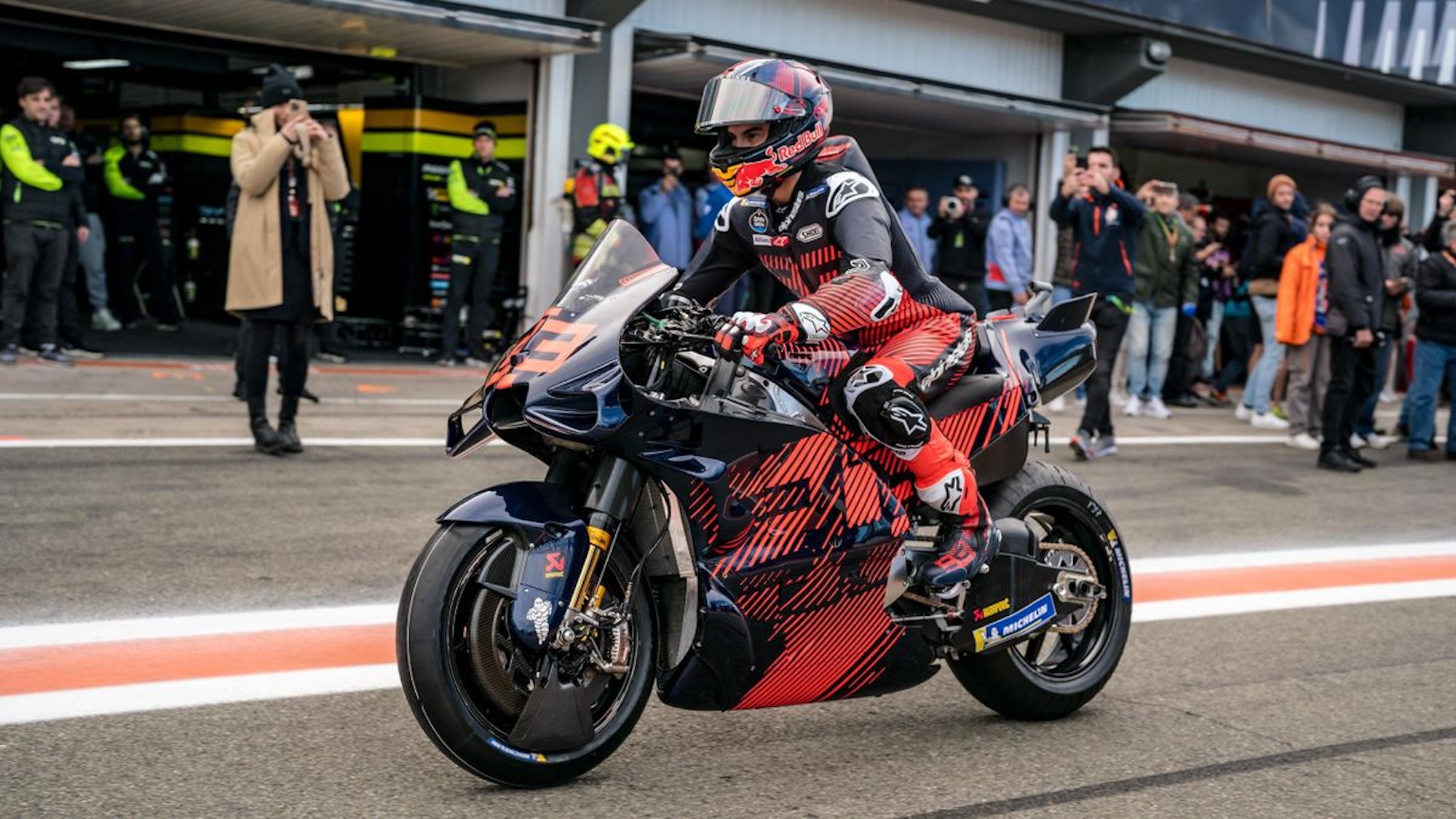 A front view of a MotoGP rider on a race track.