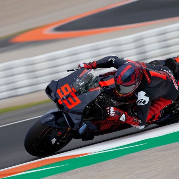 A front view of a MotoGP rider on a race track.