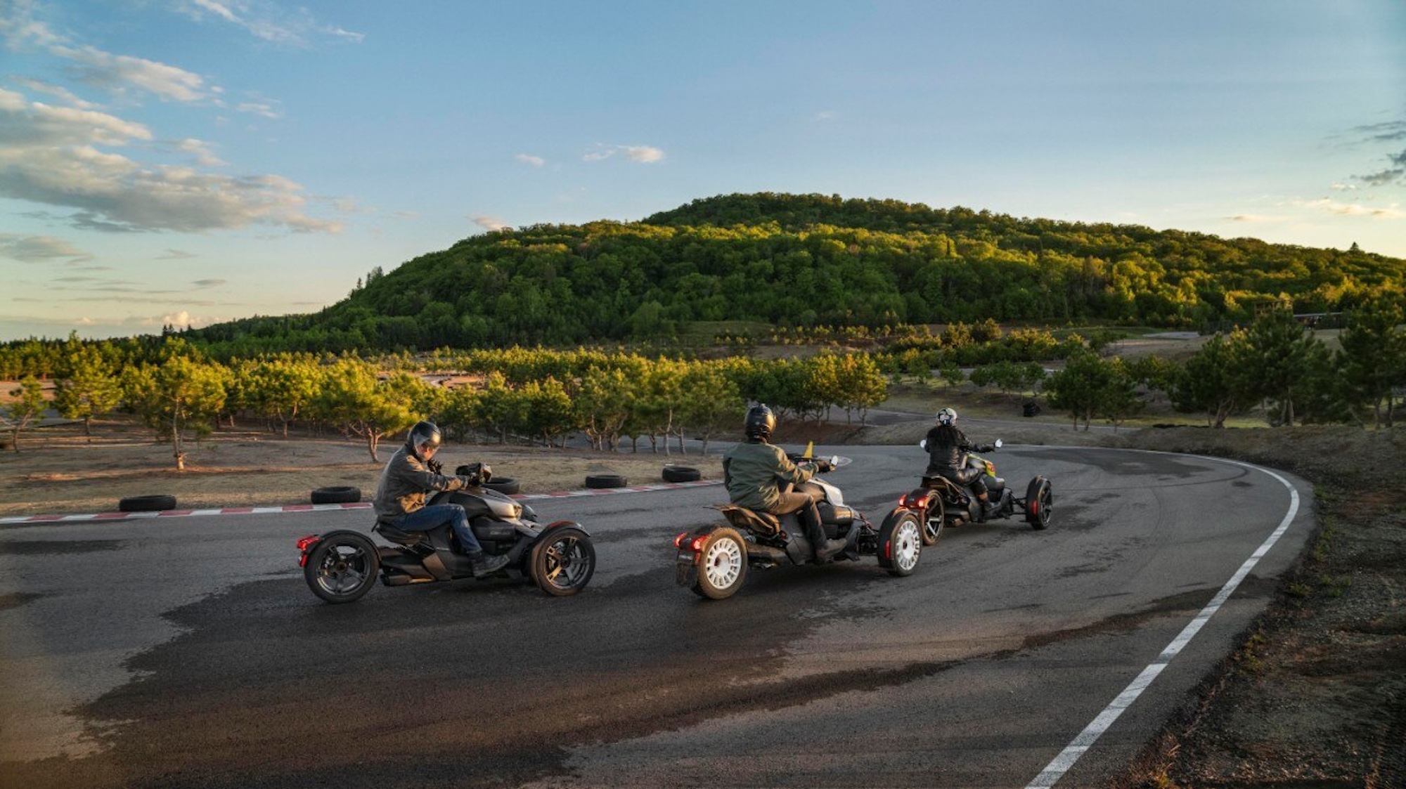 Three riders on three-wheeled motorcycles.