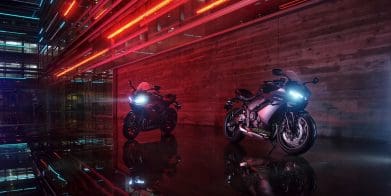 Two Triumph sportbikes parked in front of an urban building.