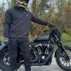 Devan wearing the Defender Motorcycle Hoodie posed in front of a Harley Davidson