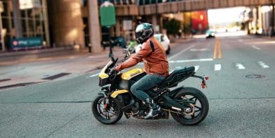 A side view of a guy on a motorcycle.