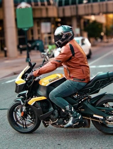 A side view of a guy on a motorcycle.