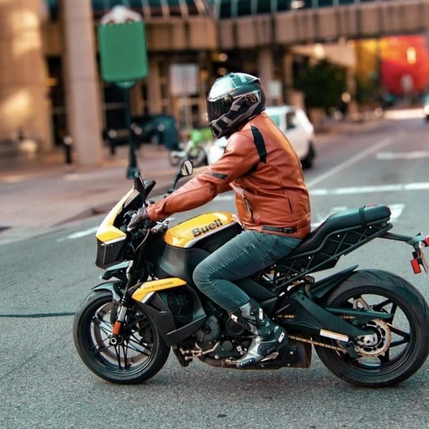 A side view of a guy on a motorcycle.