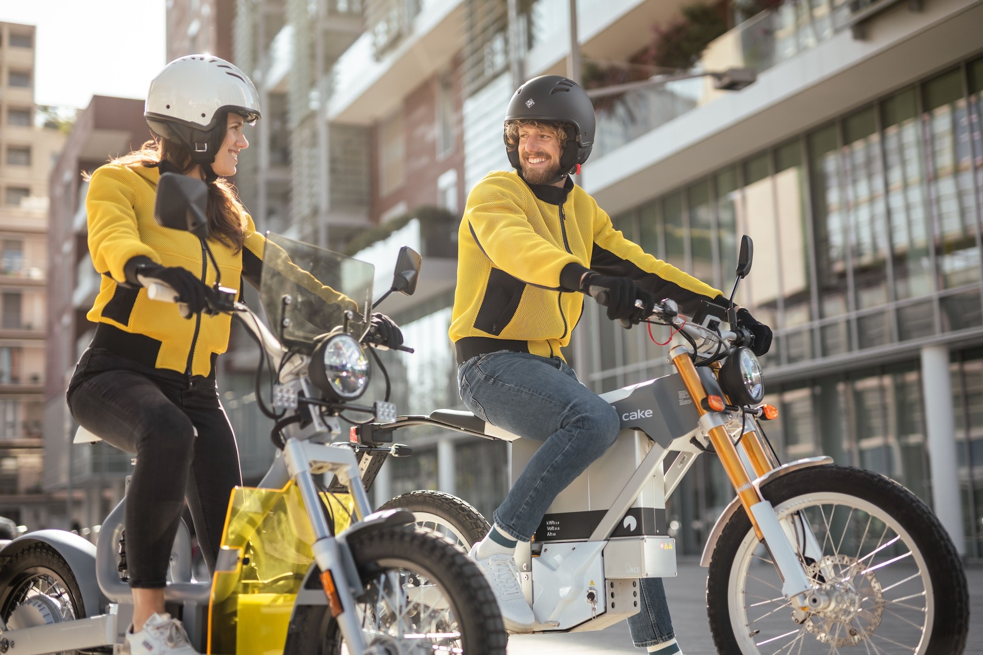 A man and a woman riding electric motorcycles. 