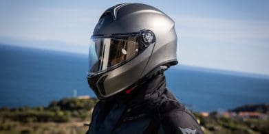 A motorcyclist wearing a helmet on a motorcycle.