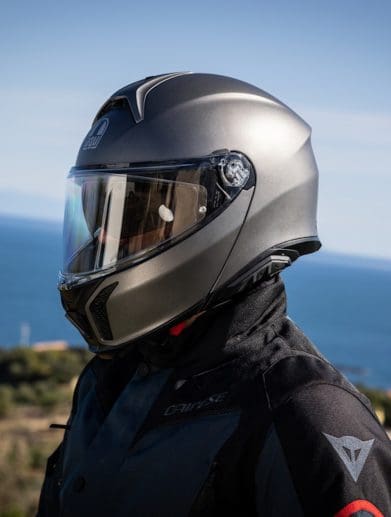 A motorcyclist wearing a helmet on a motorcycle.