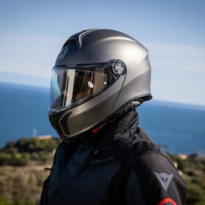A motorcyclist wearing a helmet on a motorcycle.