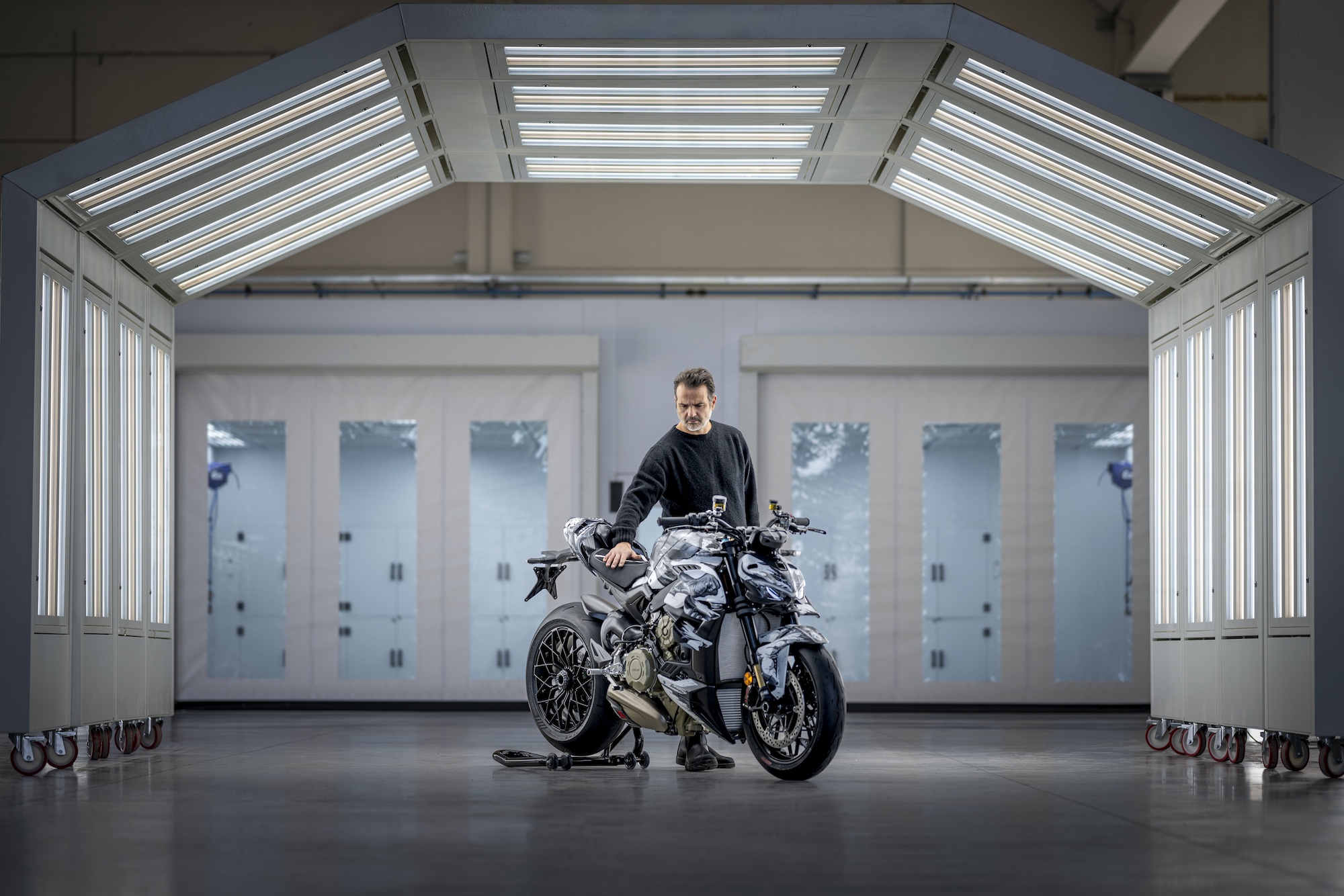 A man standing next to a motorcycle.