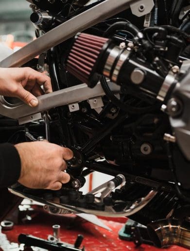 hands working on a motorcycle