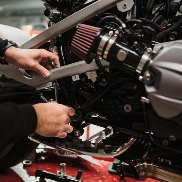 hands working on a motorcycle