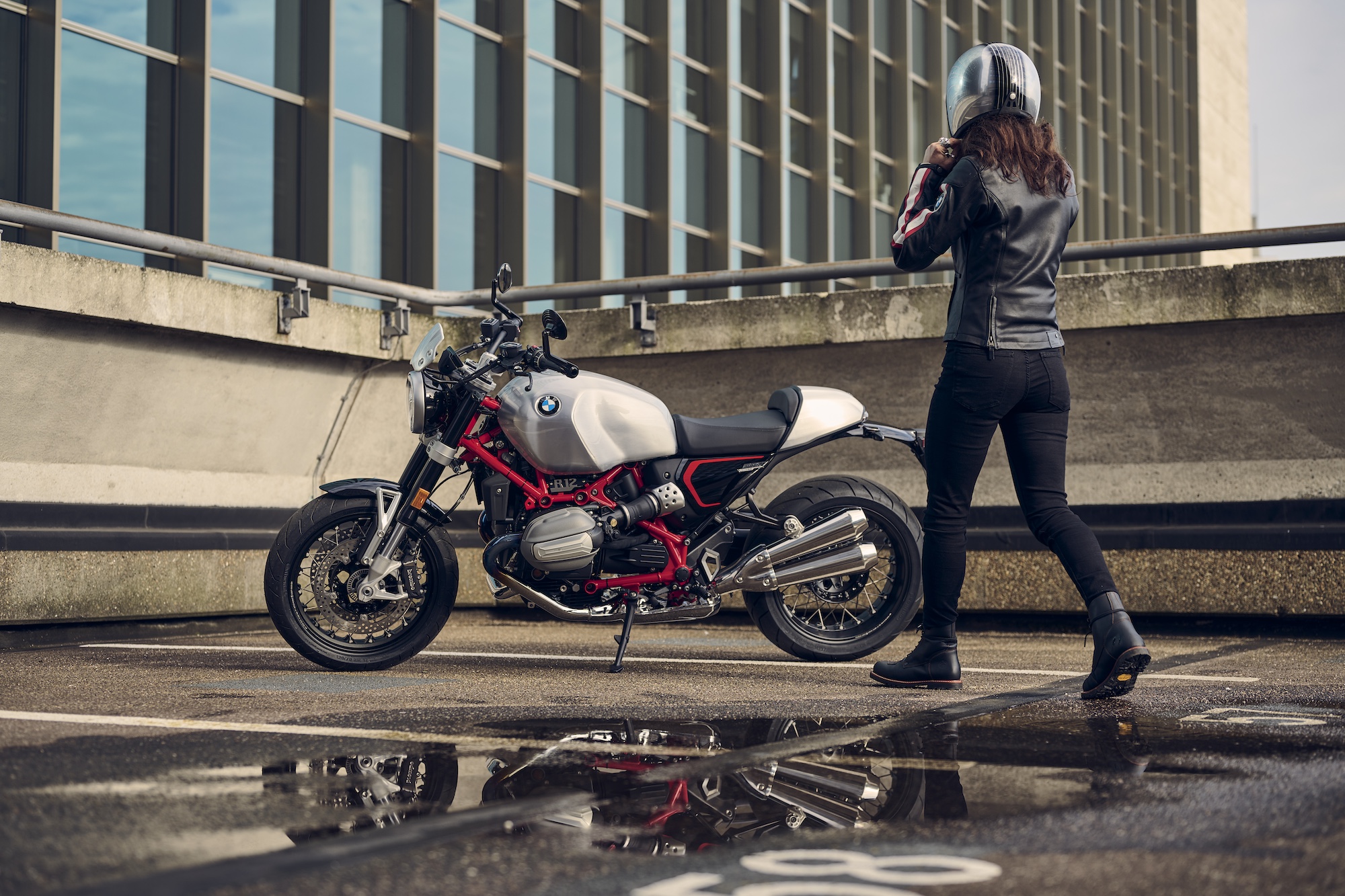 A woman walking toward a motorcycle.