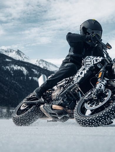 A motorcyclist with studded tired on ice.