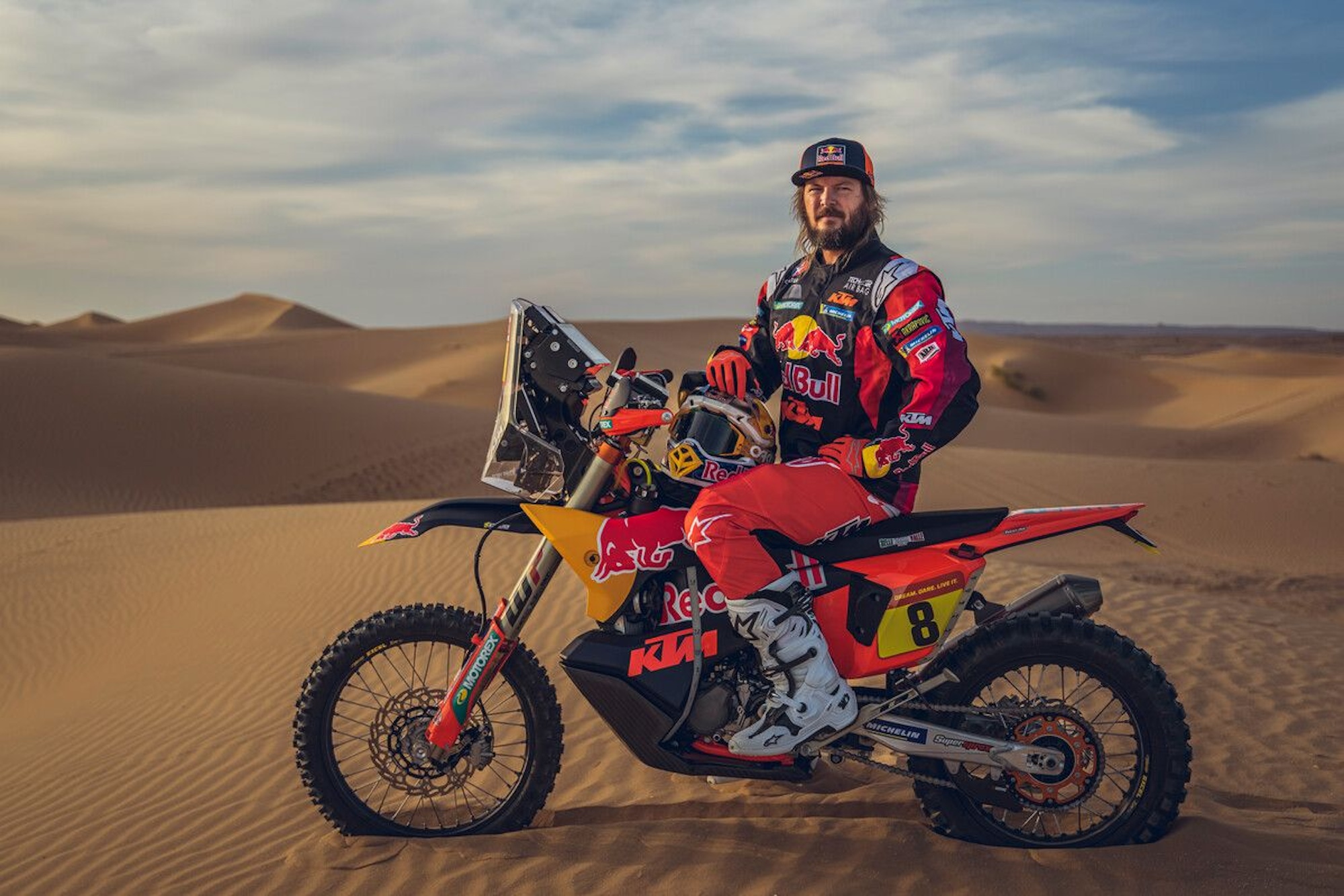 A rally racer in the sand dunes.