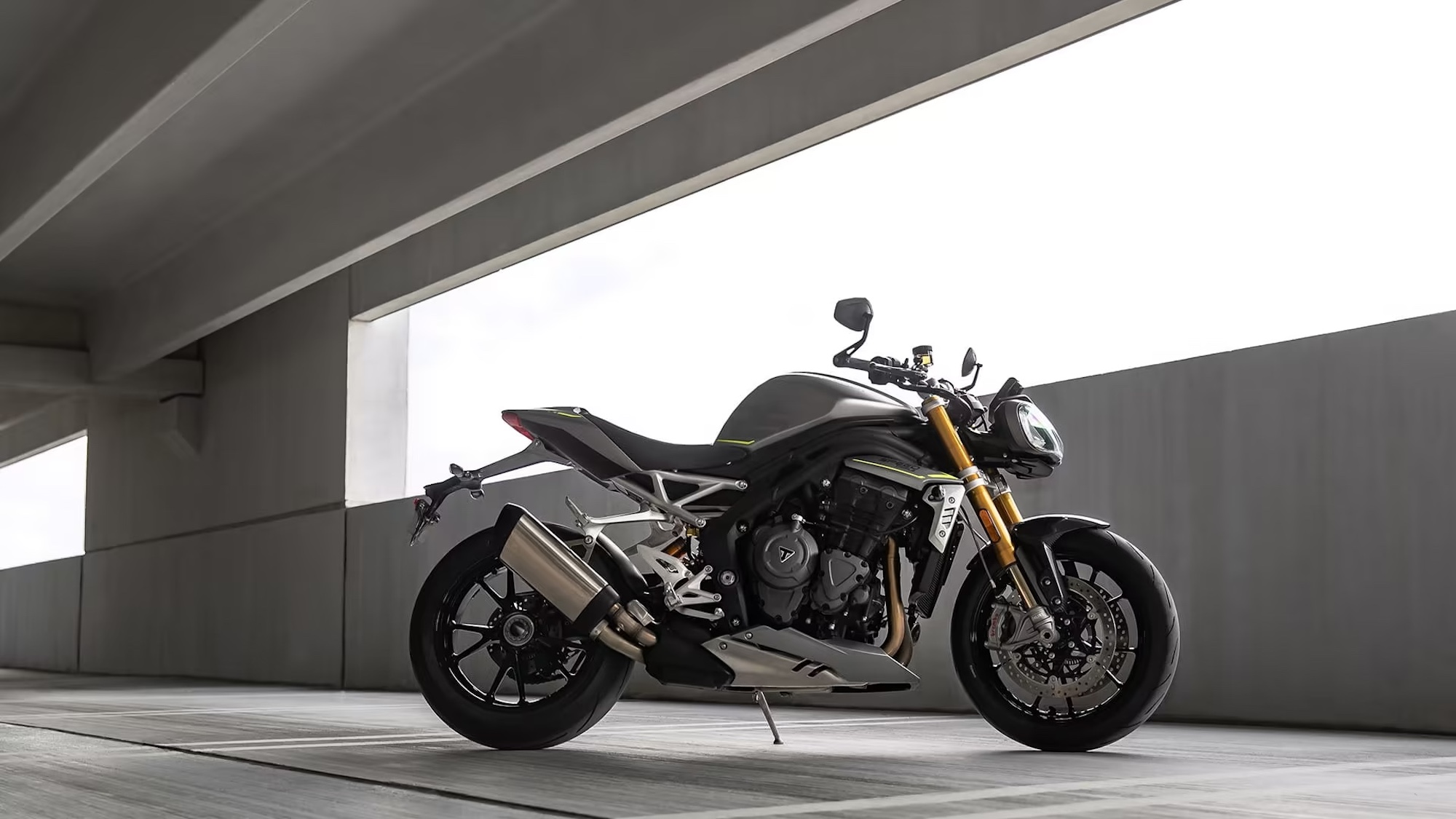 A Triumph motorcycle in a parking garage.