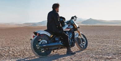 A man on a motorcycle in the desert.