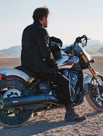 A man on a motorcycle in the desert.