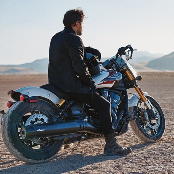 A man on a motorcycle in the desert.