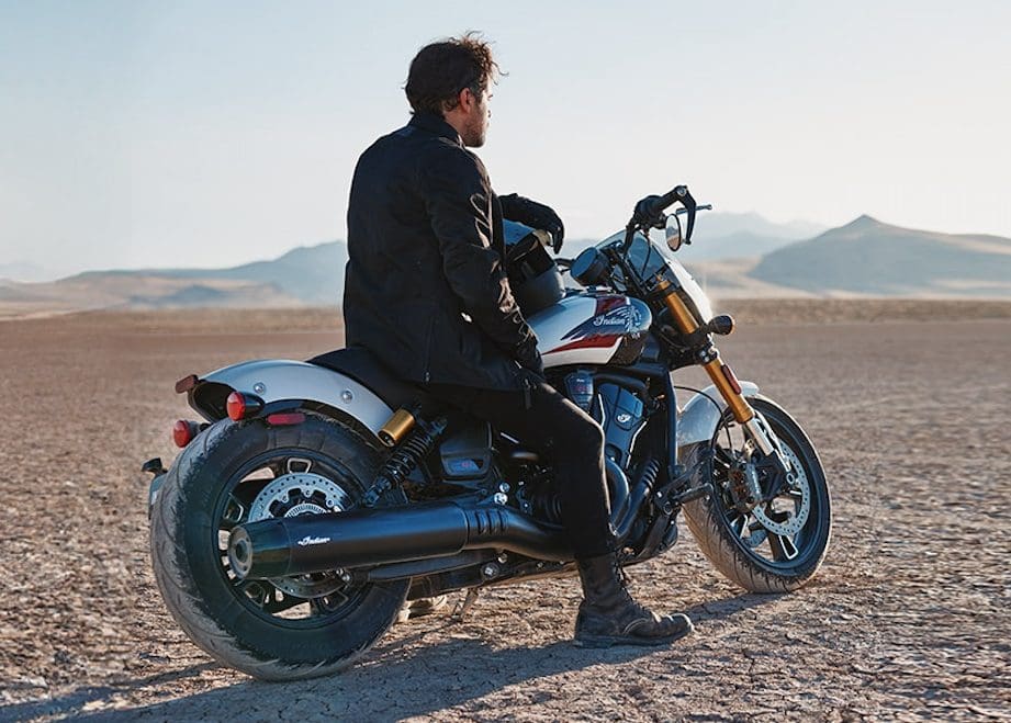 A man on a motorcycle in the desert.