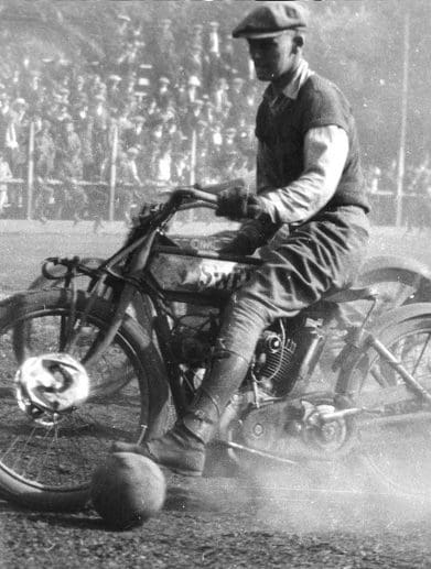 A motorcyclist playing ball.
