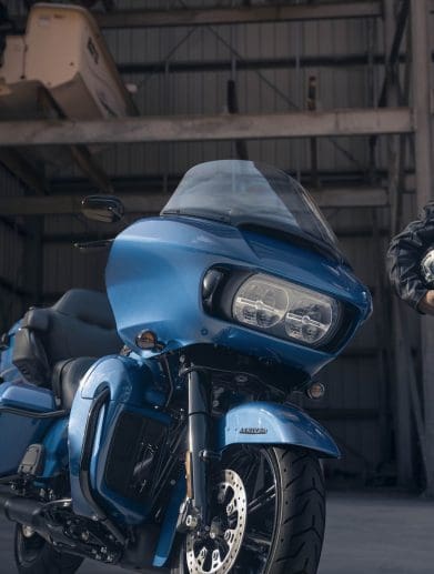A front view of a man standing next to a Harley-Davidson's 2024 Road Glide Limited.