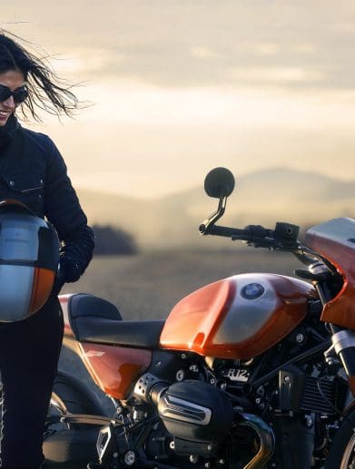 A woman standing next to a BMW bike.