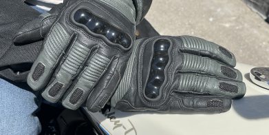 TOURMASTER Super Warm Waterproof Gloves resting on eachother on top of harley davidson tank.