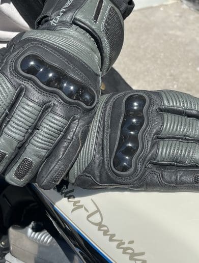 TOURMASTER Super Warm Waterproof Gloves resting on eachother on top of harley davidson tank.