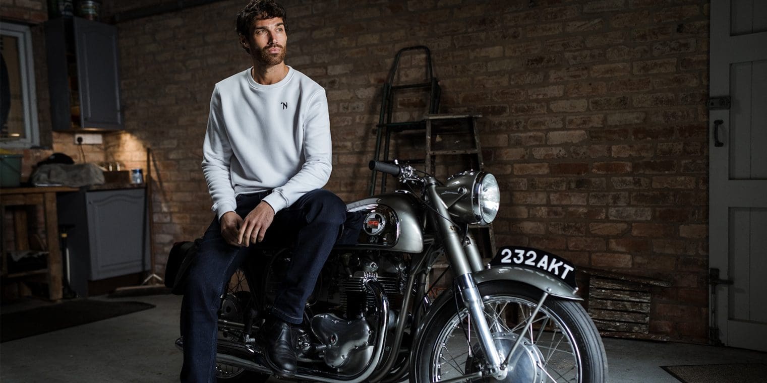 A view of a man atop a Norton motorcycle.
