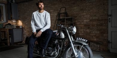 A view of a man atop a Norton motorcycle.