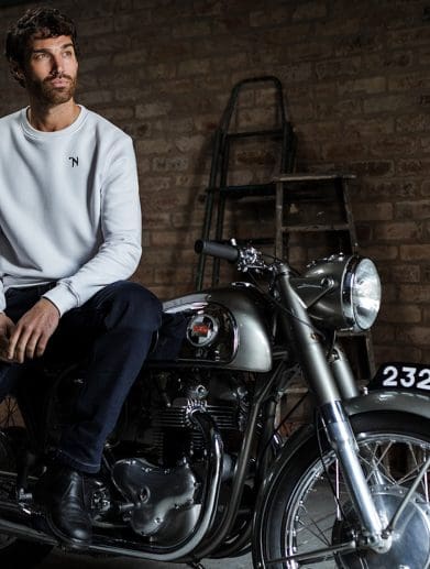 A view of a man atop a Norton motorcycle.