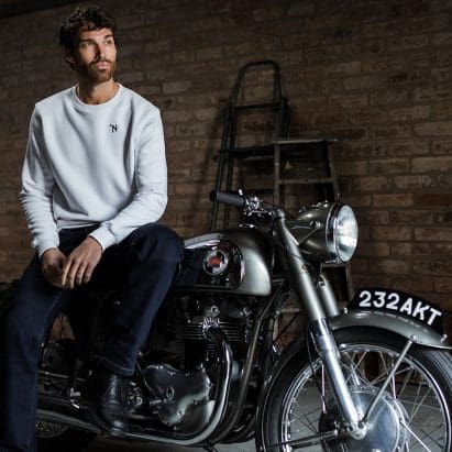 A view of a man atop a Norton motorcycle.