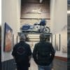 A picture of Artie Starrs (Harley-Davidson's new CEO) set against the backdrop of a hallways in Indian Motorcycles' factory, with new CEO Mike Kennedy placed at the right. Media sourced from Wuhan Talks and Indian Motorcycles.